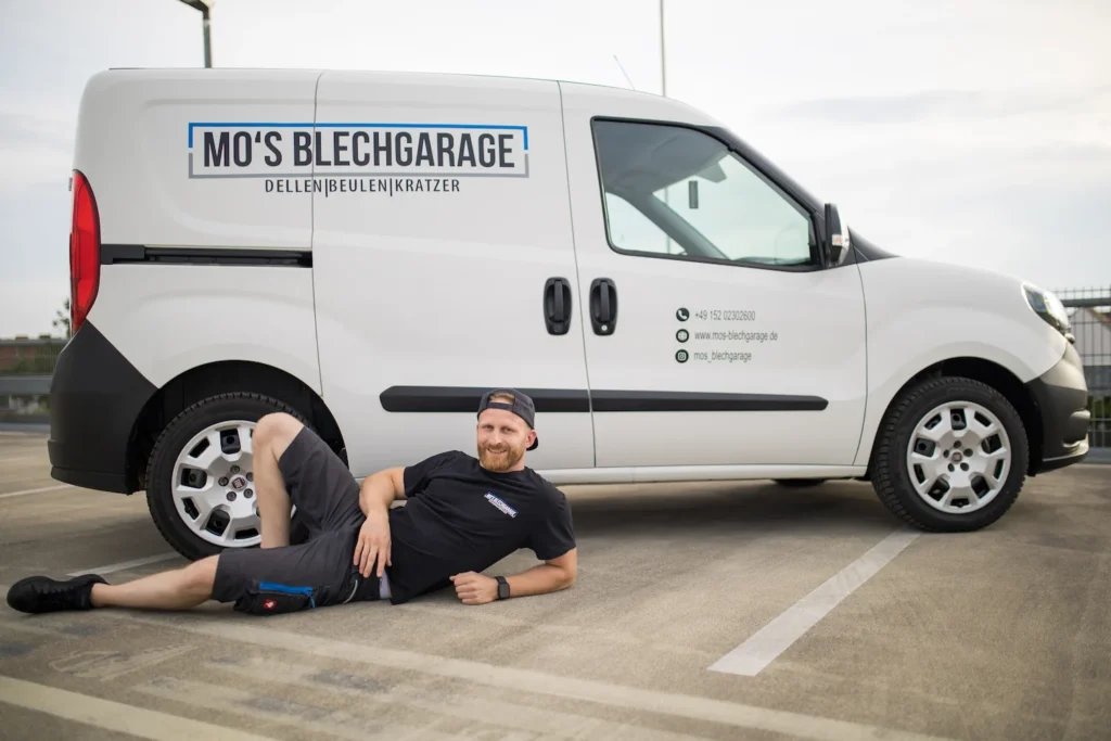 Moritz lehnt am Servicefahrzeug von Mo's Blechgarage