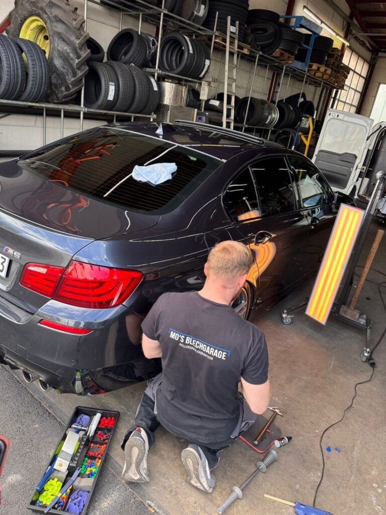 Moritz Tschech poliert und repariert einen BMW in der Werkstatt